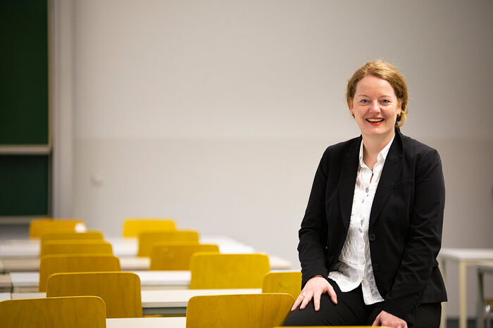 Foto Professorin Lächelnde Professorin sitzt im Hörsaal