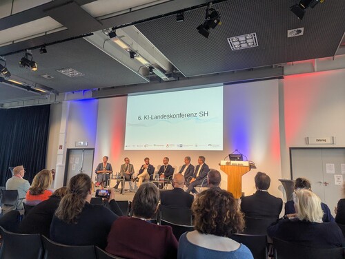 Podiumsdiskussion mit mehreren Experten und Publikum bei der 6. KI-Landeskonferenz Schleswig-Holstein.