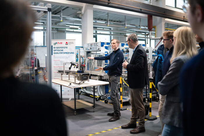 Mann präsentiert Demonstrator in Maschinenhalle