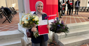 Person mit Blumen und Zertifikat.