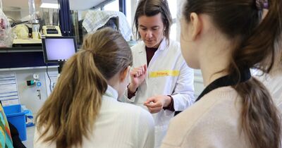 Eine Wissenschaftlerin hält einen Glasträger in der Hand.