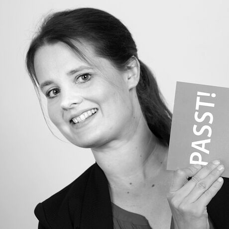 Schwarz-Weiß Foto einer Frau mit einem Schild auf dem Passt steht