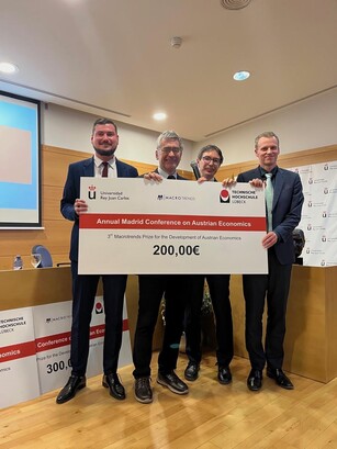 Four men hold up a large ceremonial prize check for 200,00€.