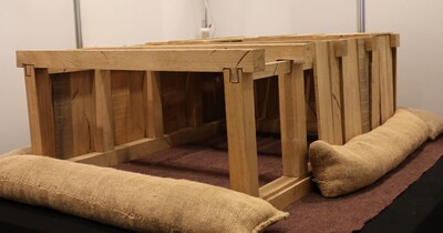Ein Gestell aus Holz, dass auf einem Tisch steht. Eine Nachbildung eines Kellers.