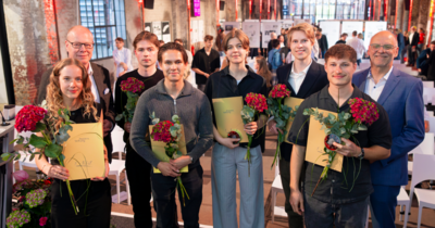 Gruppenbild mit mehr Menschen und goldenen Urkunden 
