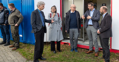 Zu sehen sind von links nach rechts: Bürgermeister der Stadt Reinfeld Roald Wramp (v.l.), Präsidentin der TH Lübeck Dr. Muriel Helbig, Umweltminister Tobias Goldschmidt, Projektleiter und Leiter der VAK Prof. Dr.-Ing. Kai Wellbrock und Co-Projektleiter Prof. Dr. Philipp Zantout-Wilfert vor einem Container der Pilotanlage.