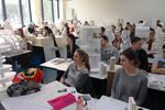 Voller Hörsaal mit Studierenden und deren Modellhäusern