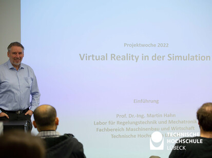 Thema Virtual Reality in der Simulation Mann steht vor einer Leinwand die eine Präsentation abspielt