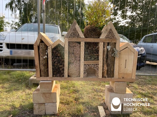 Das Bild zeigt ein vier Insektenhotel mit mehreren Ebenen nebeneinander