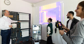 Professor und drei Studierende stehen vor einem Infrarrotbild