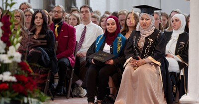 Drei Frauen sitzen in der ersten Reihe zusammen.
