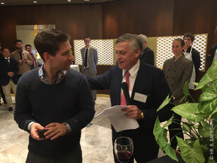A presenter with a microphone speaks kindly to a man at a reception.