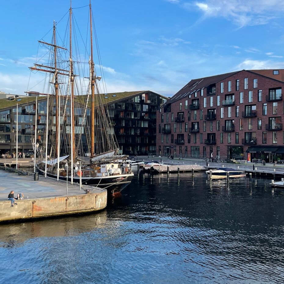 Bild zeigt Fluss, Anlegehafen und Häuserkomplexe