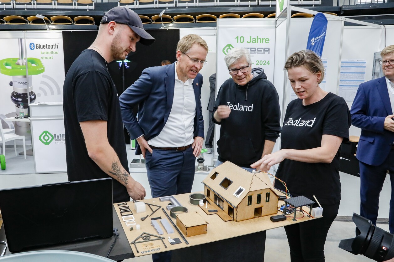 Foto Studierende Drei Personen erklären einer vierten anhand eines Modells etwas