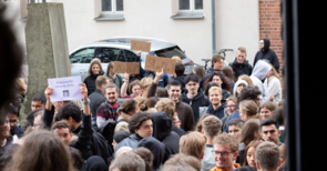 Junge Menschen halten Schilder mit ihren Studiengängen hoch.