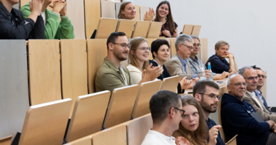 Menschen sitzend im Vorlesungssaal, klatschend