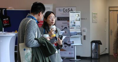 Zwei Studierende unterhalten sich bei einem Kaffee.