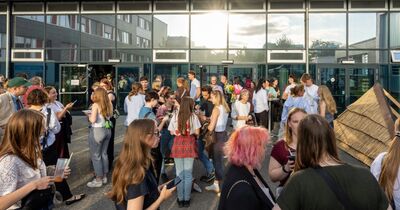 Menschen stehen vor der Glasfront des Bauforums.