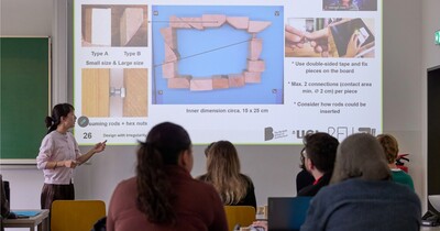 Einige Menschen sitzen in einem Seminarraum und schauen auf eine Präsentation.