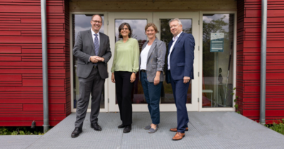 Gruppenfoto von vier Menschen vor rotem Gebäude