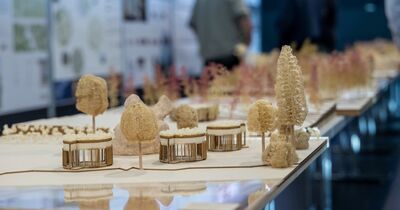 Ein Modell aus Holz mit mehreren Hütten und Bäumen.