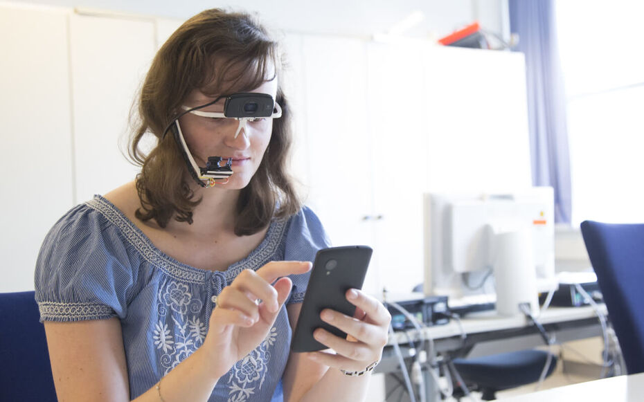 Eine Studentin trackt die Position Ihrer Augen beim Bedienen eines Userinterfaces auf dem Handy
