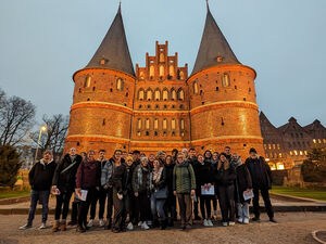 Eine Gruppe von Studierenden vor dem Lübecker Holstentor