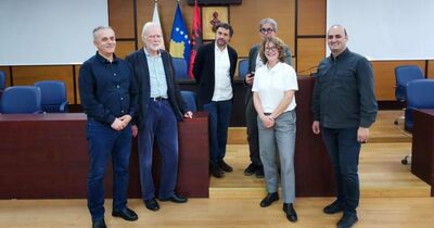 Eine Gruppe von Menschen in einem Parlamentssaal in Pristina.