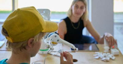 th_luebeck_juniorcampus_roboterarm Kind schneidet mit Roboterarm und heißem Draht Styropor