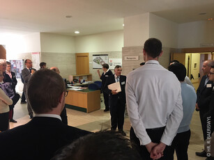 A group of conference attendees talking in a reception area.