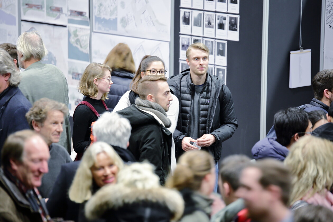 Dichtes Gedränge bei einer Ausstellung, Besucher stehen vor Infowänden.
