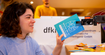 Eine Frau und ein Roboter Eine Frau bekommt von einem Roboter eine Karte gereicht