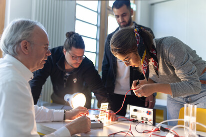 Studierende Vier Personen arbeiten gemeinsam an einem Tisch