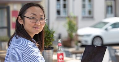 Studentin sitzt draußen vor einem Laptop