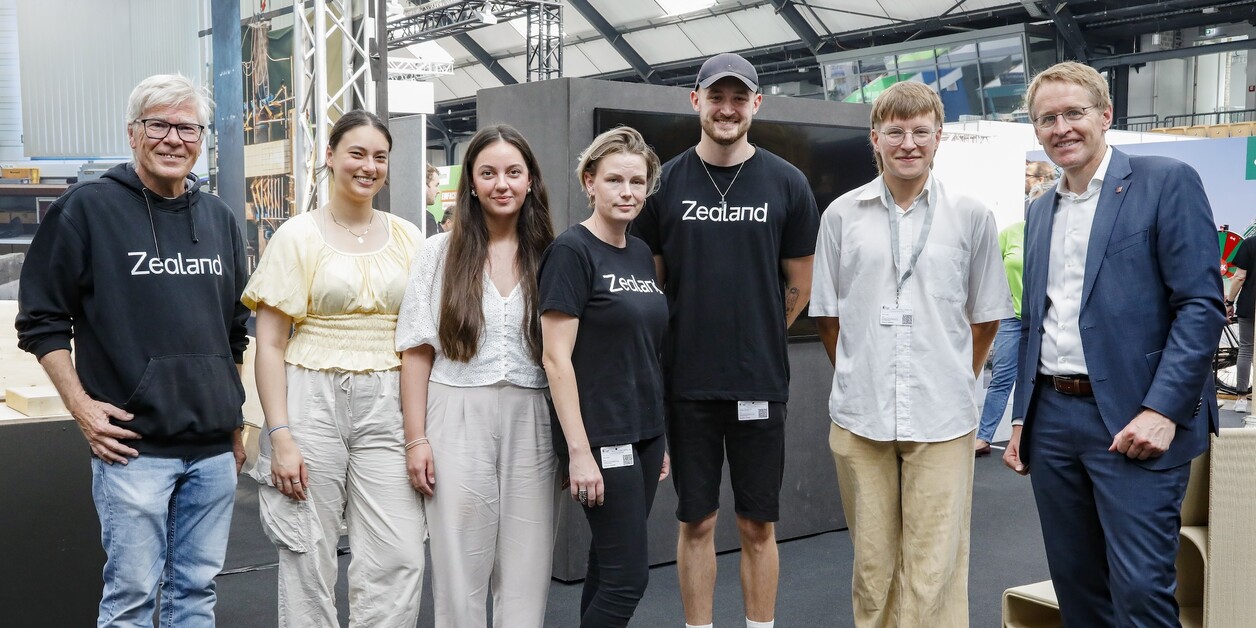 Teilnehmende 7 Personen stehen lächelnd nebeneinander