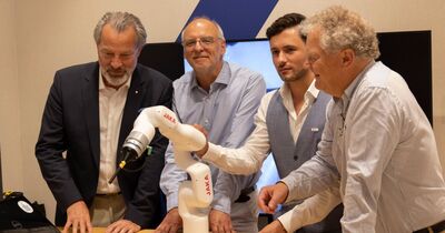 th_luebeck_dlc_roboter Vier Männer stehen hinter einem Roboter-Prototyp