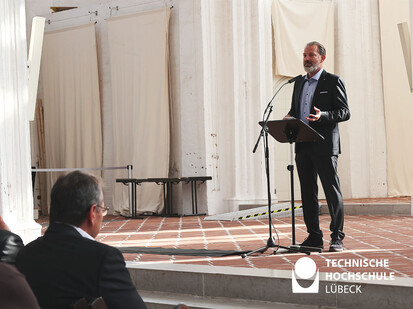 Rede des Stadtpräsidenten Auf diesem Bild sieht man einen Mann vor einem Rednerpult stehen.