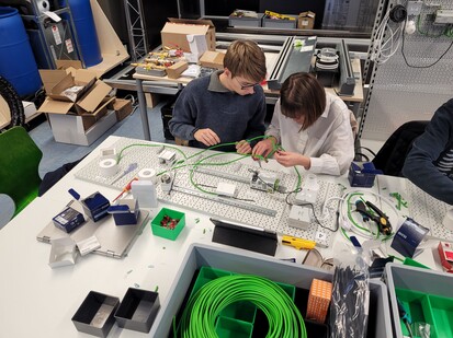 Aufbau Anlage Zwei Studierende sind sehr konzentiert und arbeiten an einer Installation