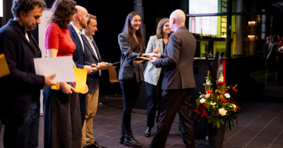 Ein Mann schüttelt einer lachenden Frau die Hand