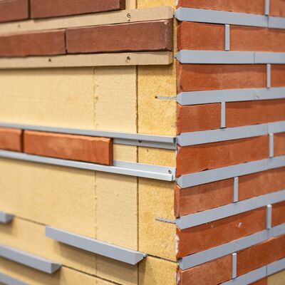 Backsteinwand hat offene Stellen die eine braune Fassade zeigen