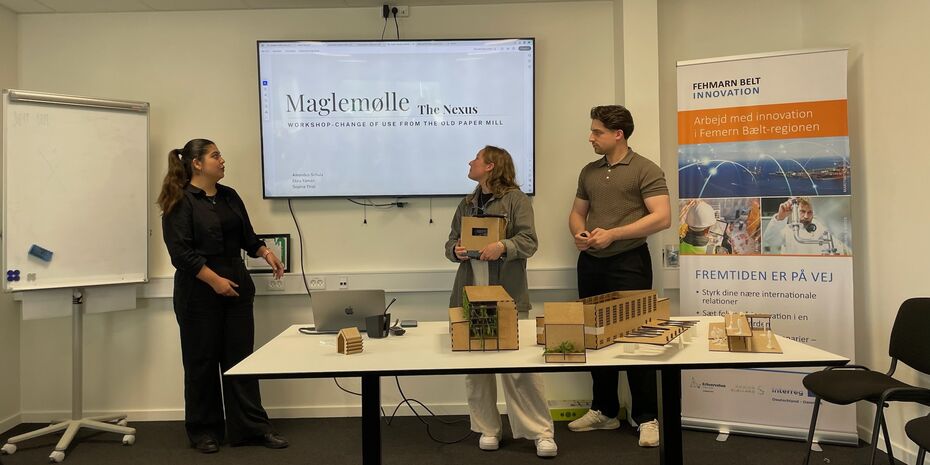 Drei Personen präsentieren ihre Modellhäuser