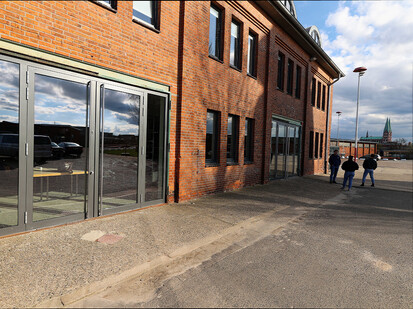 Bild zeigt Fassade des Atelier und einen Kirchturm im Hintergrund