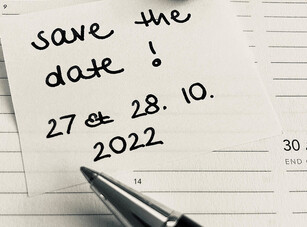 A handwritten note "save the date! 27 & 28. 10. 2022" on a calendar.
