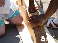 zwei Kinderhände bringen Holzklötze in die richtige Reihenfolge, um eine Brücke zu bauen. 