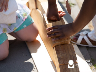 Brückenbau aus Holzklötzen zwei Kinderhände bringen Holzklötze in die richtige Reihenfolge, um eine Brücke zu bauen.