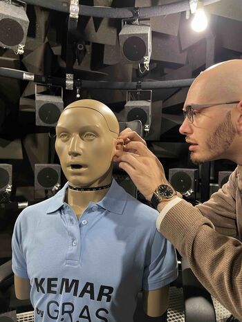 Hörakustik-Student justiert das Ohr eines KEMAR-Kunstkopfs für Messungen im reflexionsarmen Raum der TH Lübeck.