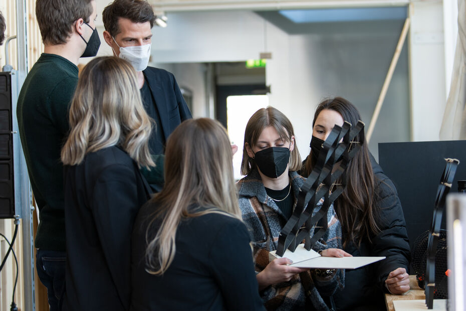 6 Personen halten oder stehen vor einer 3D gedruckten Struktur