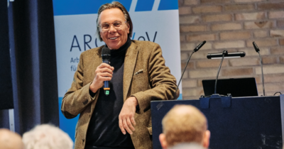 Redner mit Mikrofon spricht vor Publikum bei den Lübecker Baugesprächen 2026