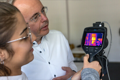 Studierende Zwei Personen gucken auf Bildschirm einer Thermografiekamera