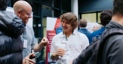 Zwei Männer in einer Menschenmenge, unterhalten sich 